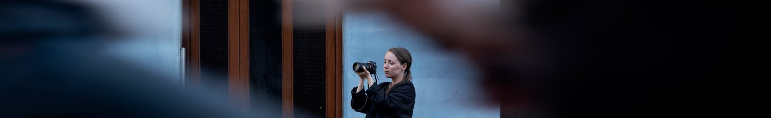 Fotograf med kamera omringet av mennesker